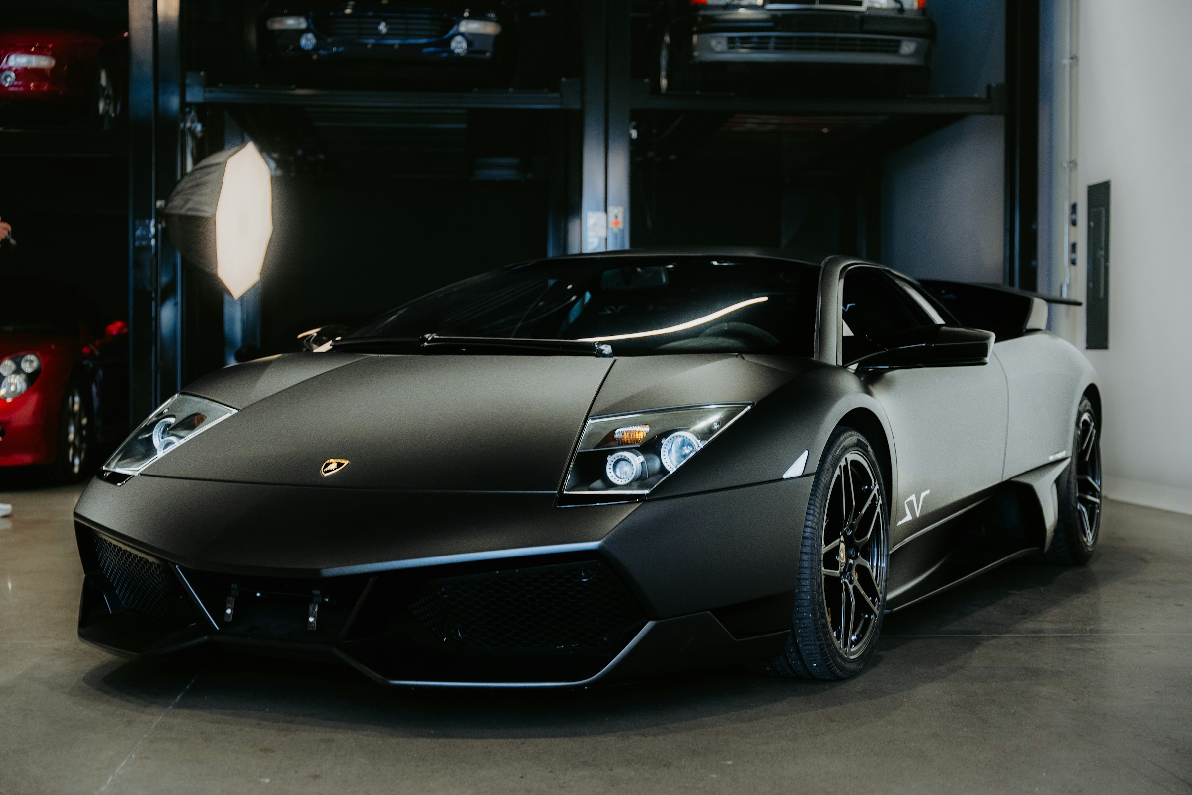 Matte-black Lamborghini in a private luxury showroom